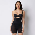 Woman wearing a black shapewear bodysuit against a plain background